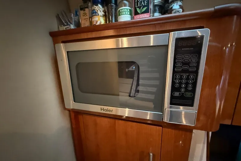 Valubelle Yacht Photos Pics Haier microwave in 2012 Regal 35 Sport Coupe kitchen, surrounded by wooden cabinetry.