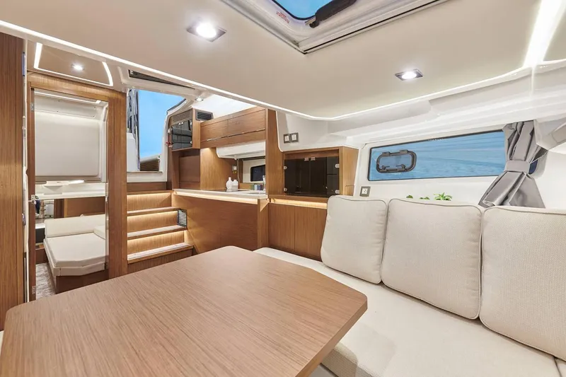  Yacht Photos Pics Manufacturer Provided Image: Modern interior of 2022 Jeanneau Leader 12.5 WA yacht with cozy seating and wooden finishes.