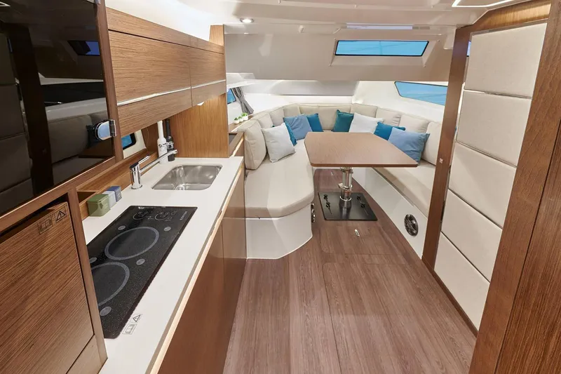  Yacht Photos Pics Manufacturer Provided Image: Interior of 2022 Jeanneau Leader 12.5 WA with modern kitchen and cozy seating area.