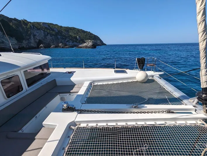  Yacht Photos Pics Lagoon 450 catamaran sailing near rocky coastline, clear blue sea, sunny day, 2014 model.