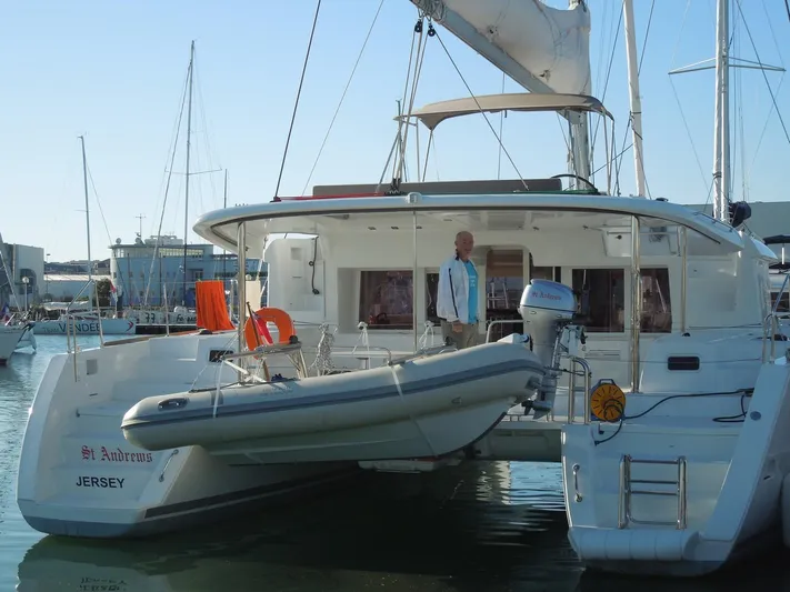  Yacht Photos Pics 2014 Lagoon 450 catamaran docked with dinghy, featuring spacious deck and modern design.