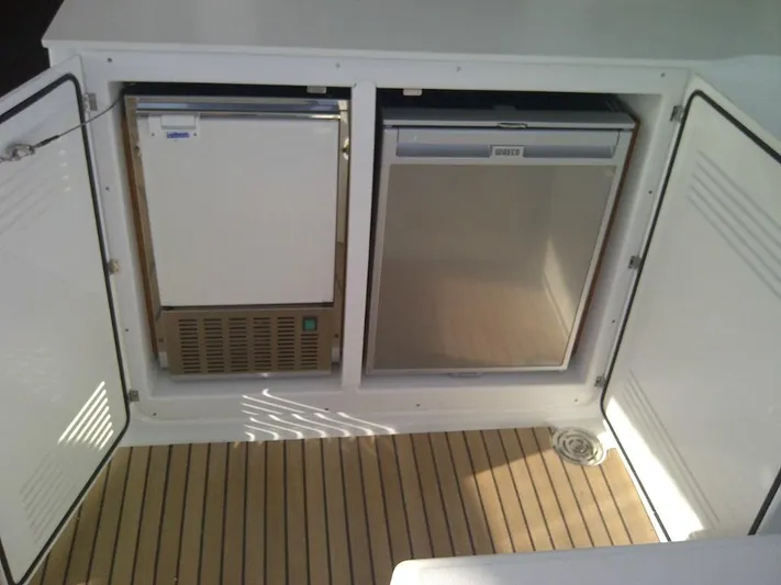  Yacht Photos Pics Built-in fridge and freezer on 2014 Lagoon 450 yacht, open cabinet doors, wooden flooring.
