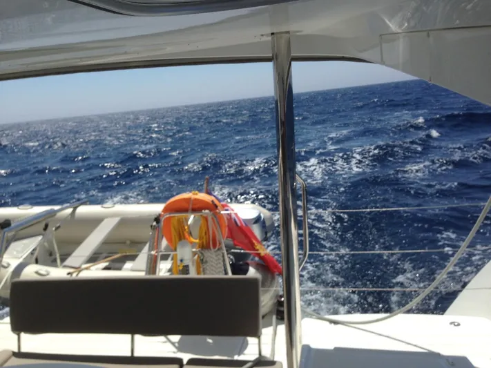  Yacht Photos Pics Lagoon 450 catamaran sailing on open sea, 2014 model, with life preserver visible.