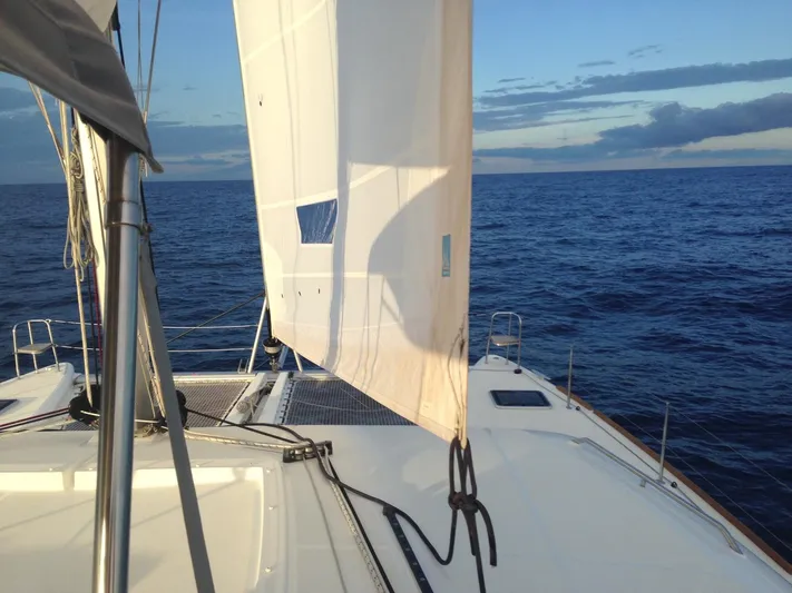  Yacht Photos Pics Sailing on a 2014 Lagoon 450 catamaran with white sails against a blue ocean backdrop.