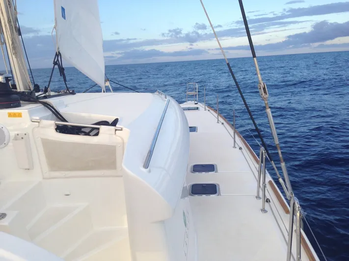  Yacht Photos Pics 2014 Lagoon 450 catamaran sailing on open sea under a cloudy sky.
