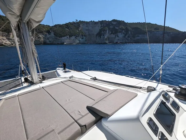  Yacht Photos Pics Lagoon 450 catamaran sailing near rocky coastline, clear blue sea, sunny day, 2014 model.