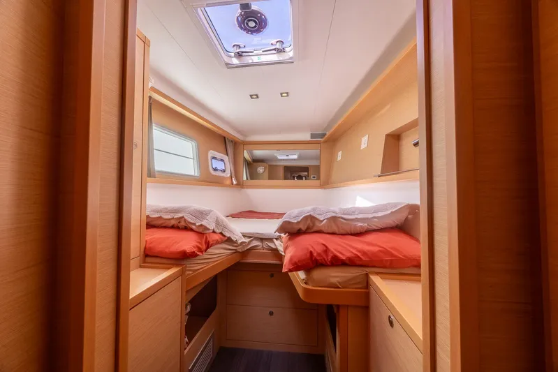  Yacht Photos Pics Luxurious cabin interior of a 2014 Lagoon 450 catamaran with cozy bedding and natural light.