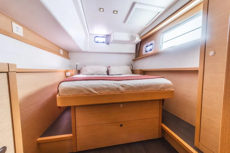  Yacht Photos Pics Luxurious cabin interior of 2014 Lagoon 450 catamaran with cozy bed and wooden furnishings.