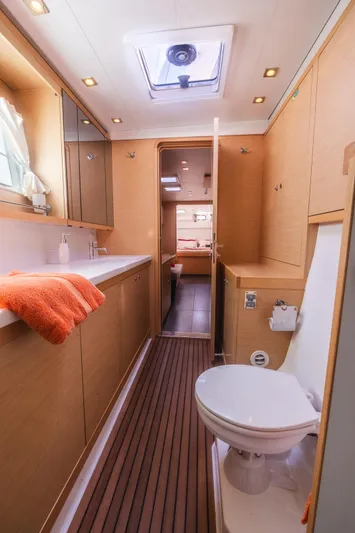  Yacht Photos Pics Luxurious bathroom interior of 2014 Lagoon 450 catamaran with modern amenities and wooden accents.