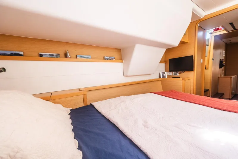  Yacht Photos Pics Luxurious cabin interior of 2014 Lagoon 450 catamaran with cozy bedding and modern amenities.