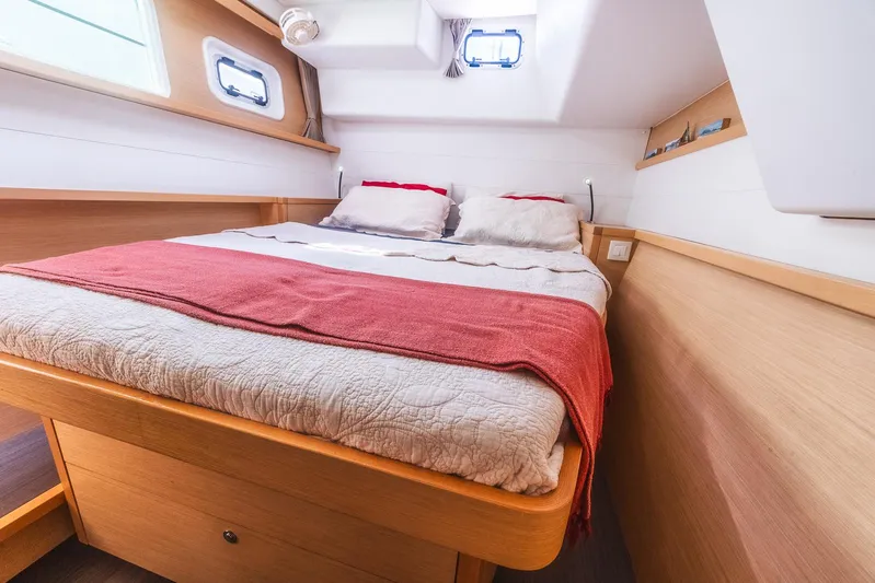  Yacht Photos Pics Cozy cabin interior of 2014 Lagoon 450 catamaran with double bed and portholes.