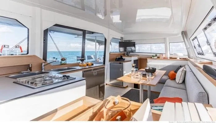  Yacht Photos Pics Manufacturer Provided Image: Luxurious interior of 2026 Excess 11 catamaran with modern kitchen and seating area.