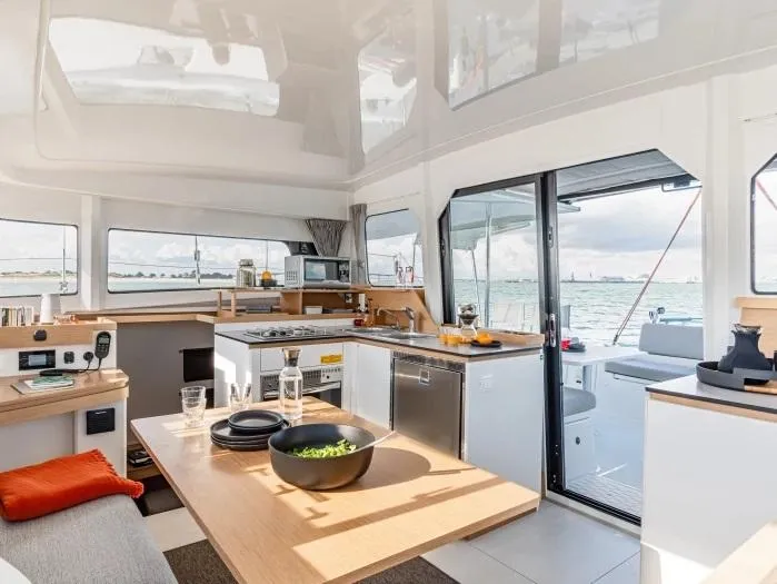  Yacht Photos Pics Manufacturer Provided Image: Luxurious interior of 2026 Excess 11 catamaran with modern kitchen and ocean view.
