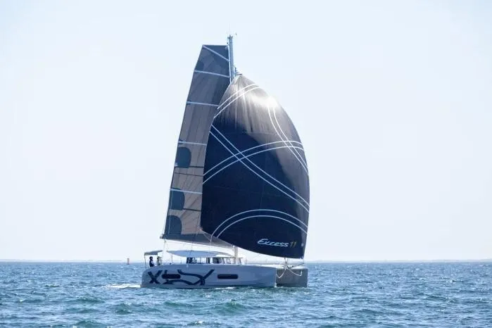  Yacht Photos Pics Manufacturer Provided Image: 2026 Excess 11 catamaran sailing on open sea with sleek black sails.