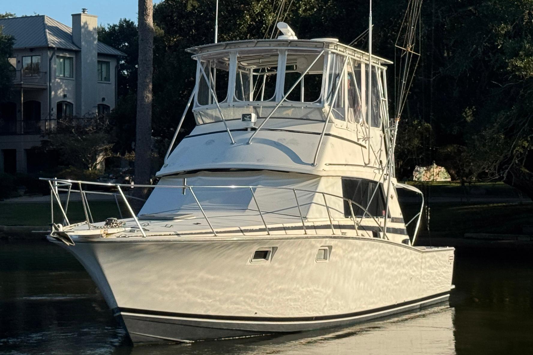 1979 Bertram 38 Convertible yacht docked near waterfront homes.
