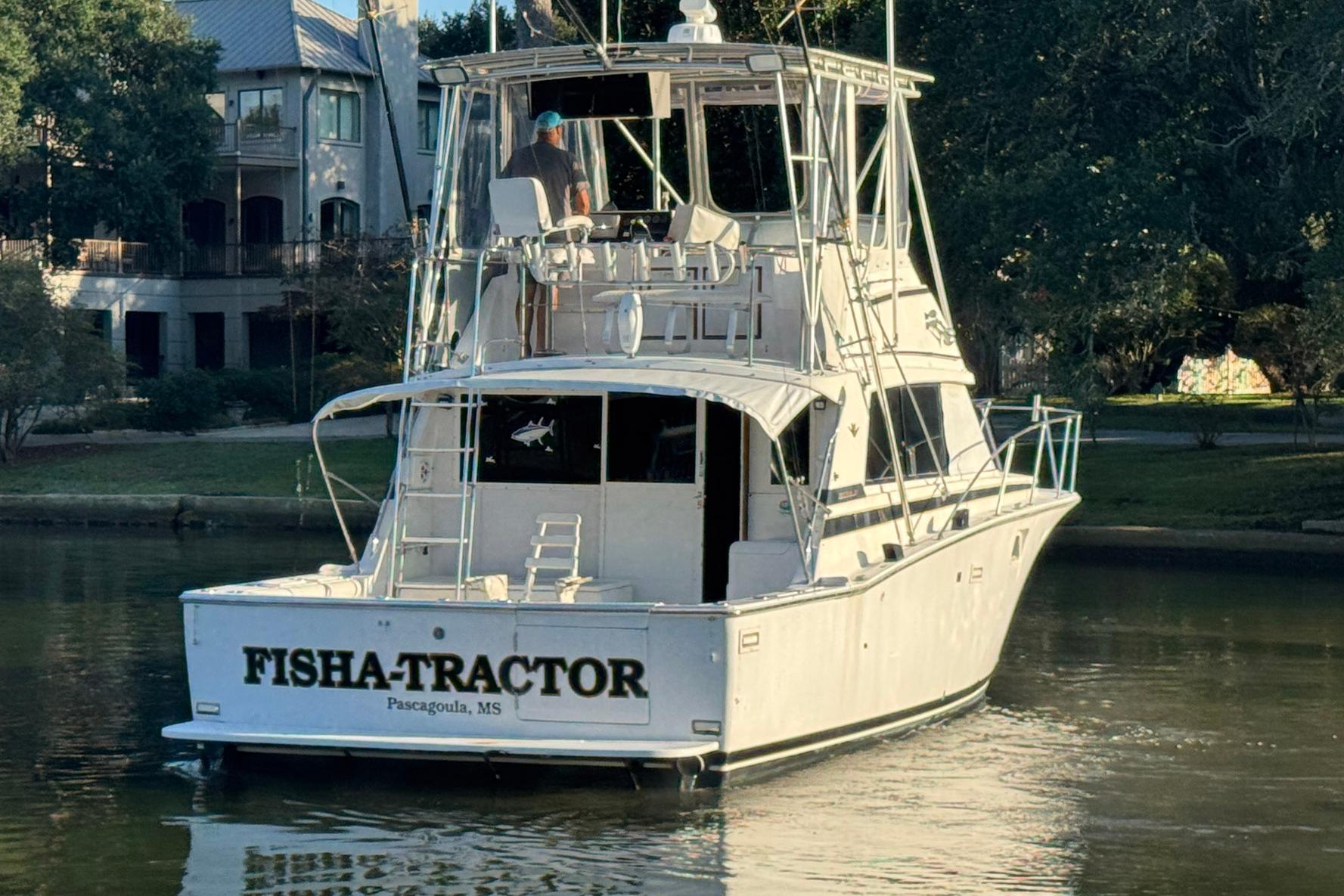 1979 Bertram 38 Convertible boat named "FISHA-TRACTOR" in a serene waterway setting.