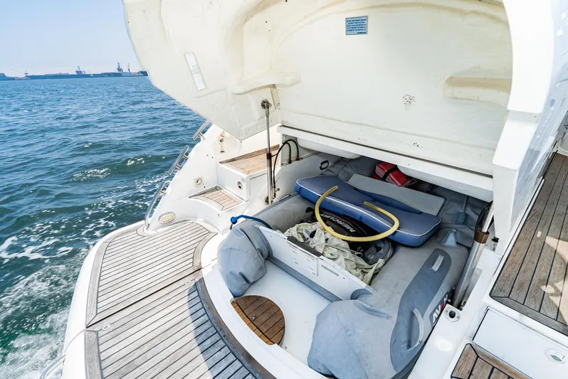  Yacht Photos Pics Fairline 48 Targa 2000 yacht with open storage compartment, docked on calm sea.