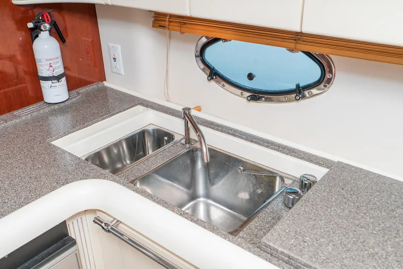  Yacht Photos Pics Kitchen sink area on a 2000 Fairline 48 Targa yacht with porthole and fire extinguisher.