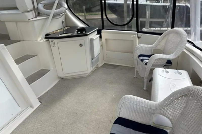 Just Blessed Yacht Photos Pics 2002 Silverton 43 Motor Yacht interior with wicker chairs and compact kitchenette.