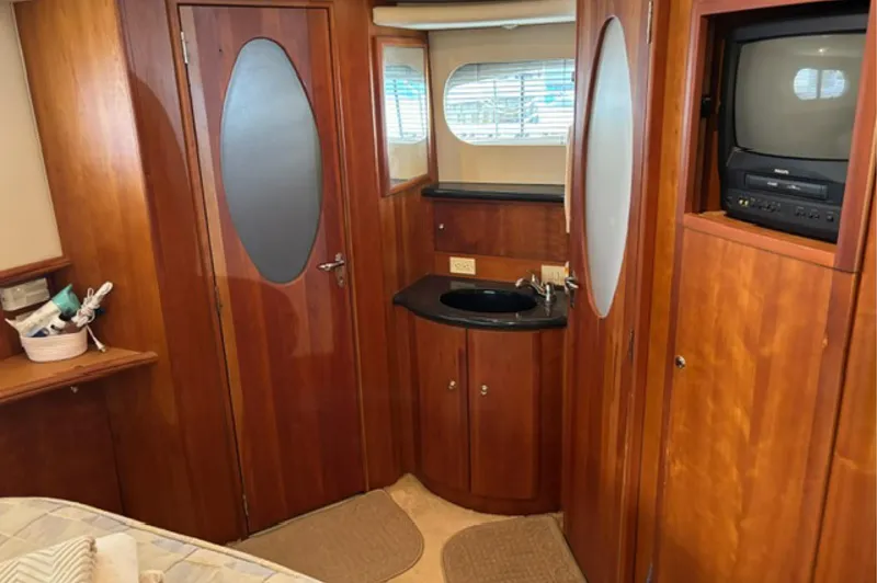 Just Blessed Yacht Photos Pics Interior of 2002 Silverton 43 Motor Yacht with wood paneling and built-in TV.