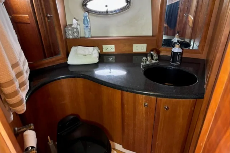 Just Blessed Yacht Photos Pics Luxurious bathroom in 2002 Silverton 43 Motor Yacht with wood cabinetry and black countertop.