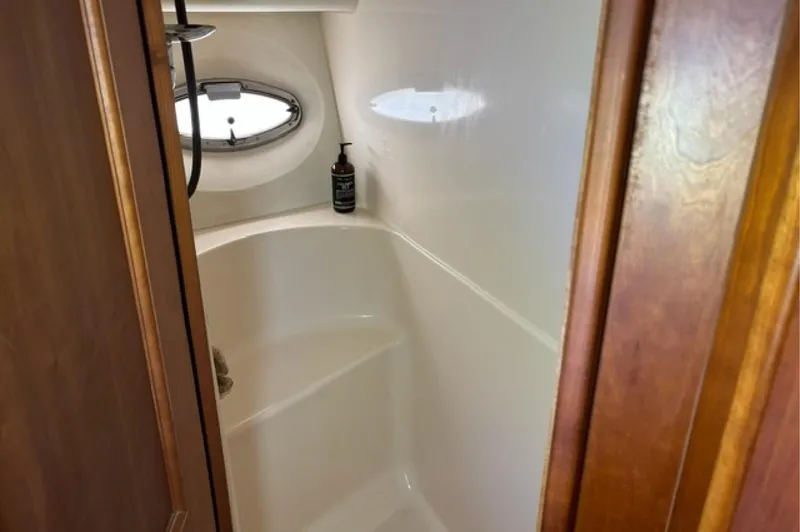 Just Blessed Yacht Photos Pics Bathroom interior of 2002 Silverton 43 Motor Yacht with porthole and wooden door.