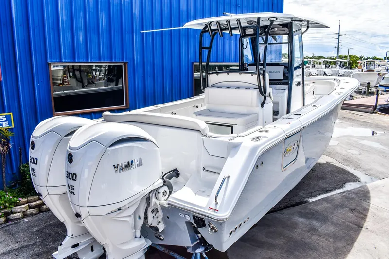  Yacht Photos Pics 2026 Sea Hunt Ultra 285 Coffin Box boat with twin Yamaha engines, docked near a blue building.