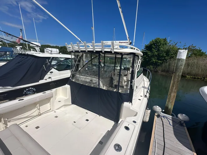  Yacht Photos Pics 2011 Pursuit OS 315 Offshore boat docked, featuring spacious deck and enclosed cabin.