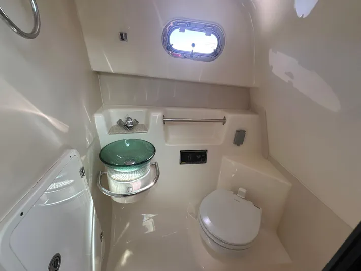  Yacht Photos Pics 2011 Pursuit OS 315 Offshore boat bathroom with modern fixtures and porthole window.