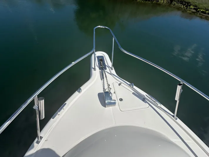  Yacht Photos Pics Bow view of 2011 Pursuit OS 315 Offshore boat on calm water.