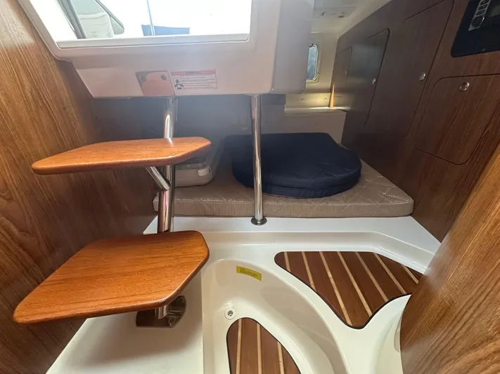  Yacht Photos Pics 2011 Pursuit OS 315 Offshore cabin interior with wooden steps and cushioned seating area.