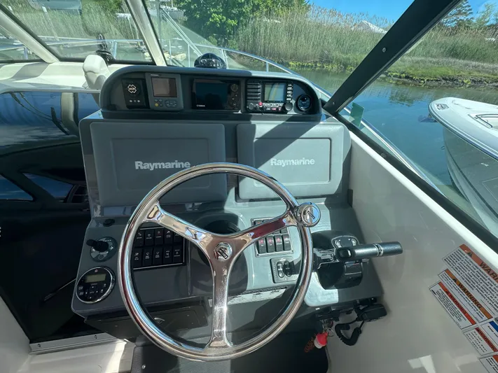  Yacht Photos Pics 2011 Pursuit OS 315 Offshore boat helm with Raymarine electronics and steering wheel.