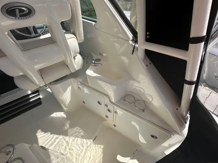  Yacht Photos Pics 2011 Pursuit OS 315 Offshore interior, featuring helm seating and storage compartments.