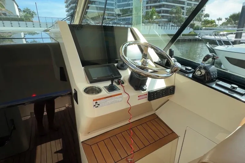  Yacht Photos Pics 2020 Scout 530 LXF boat helm with steering wheel and navigation controls.