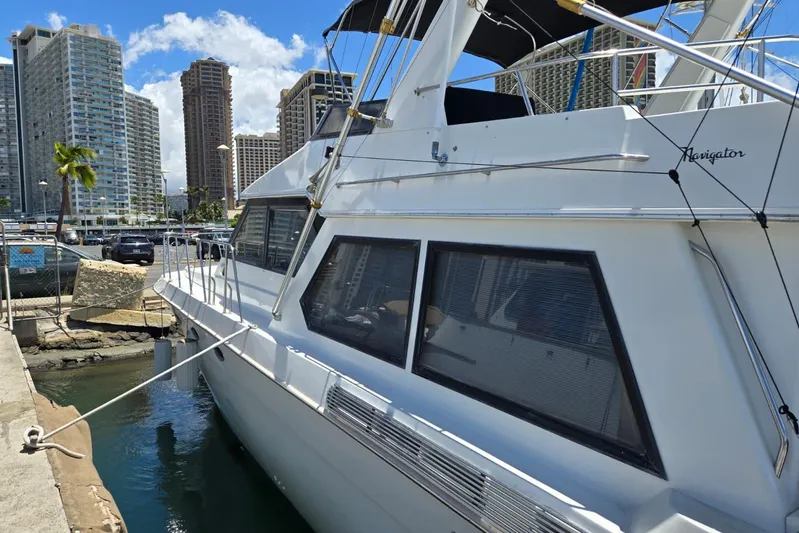  Yacht Photos Pics 1994 Navigator 5600 yacht docked in urban marina with skyscrapers in background.