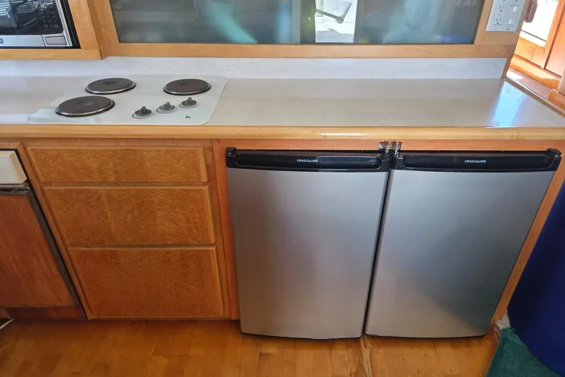  Yacht Photos Pics Compact kitchen with dual Frigidaire refrigerators and electric stovetop in a 1994 Navigator 5600.