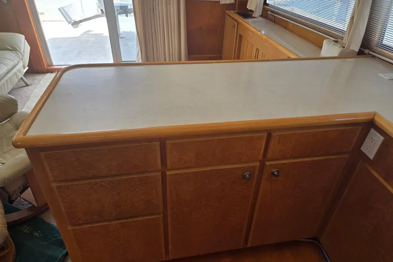  Yacht Photos Pics Wooden kitchen counter with cabinets in a 1994 Navigator 5600 boat interior.