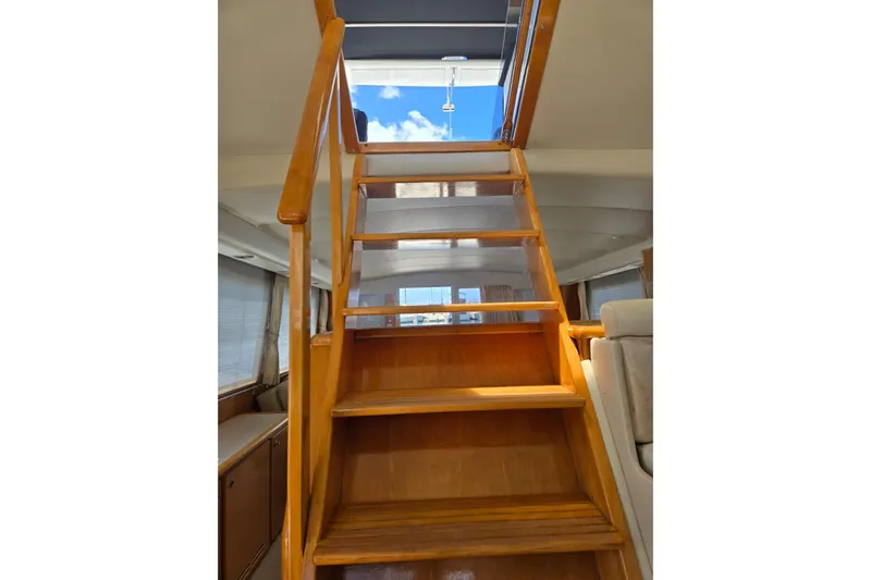  Yacht Photos Pics Wooden staircase inside 1994 Navigator 5600 yacht, leading to upper deck with skylight.