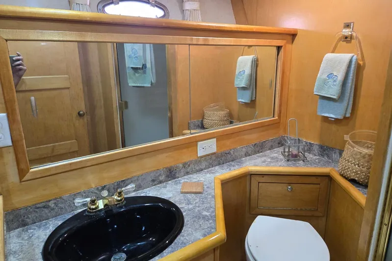  Yacht Photos Pics Bathroom interior of 1994 Navigator 5600 yacht with wooden cabinetry and black sink.