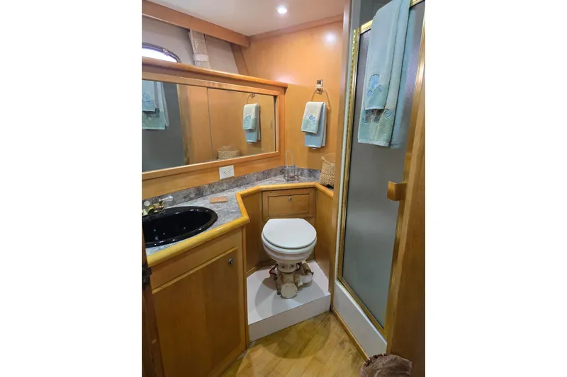  Yacht Photos Pics Bathroom interior of 1994 Navigator 5600 yacht with wood accents and modern fixtures.