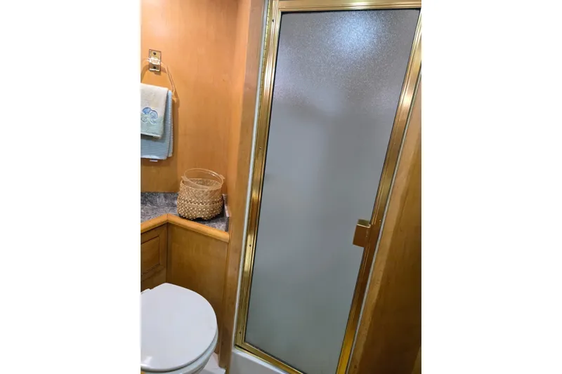  Yacht Photos Pics Bathroom in 1994 Navigator 5600 yacht with shower, toilet, and wooden cabinetry.