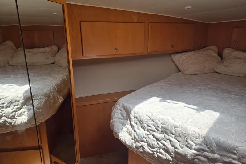  Yacht Photos Pics Cozy bedroom in 1994 Navigator 5600 yacht with mirrored closet and wooden cabinets.