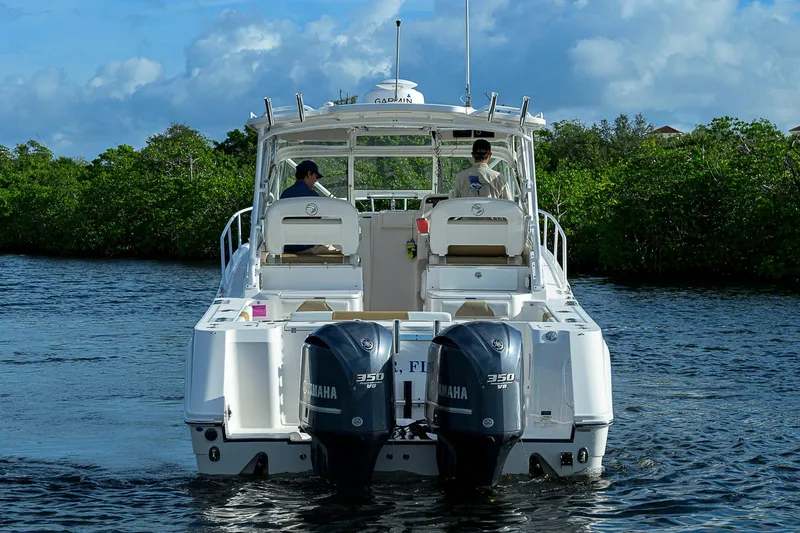 Yacht Photos Pics 2016 Edgewater 335 Express boat with dual Yamaha engines on a scenic waterway.