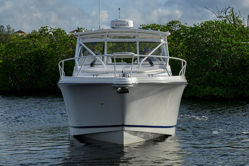  Yacht Photos Pics 2016 Edgewater 335 Express boat cruising on calm water, surrounded by lush greenery.