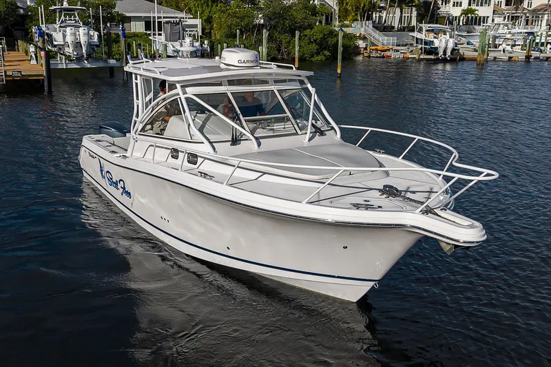  Yacht Photos Pics 2016 Edgewater 335 Express boat cruising in a marina, surrounded by docks and other boats.