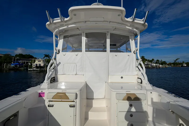 Yacht Photos Pics 2016 Edgewater 335 Express boat with enclosed cockpit, docked on a sunny day.