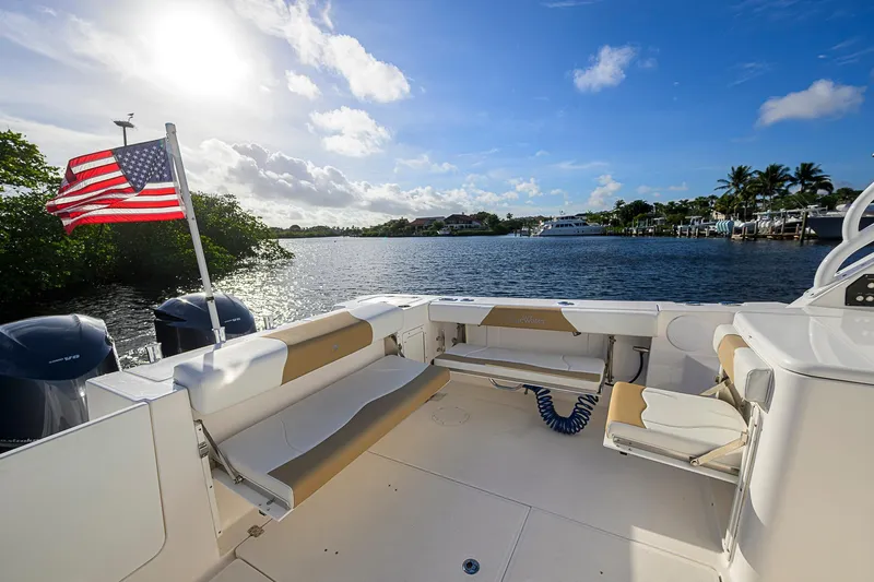  Yacht Photos Pics 2016 Edgewater 335 Express boat with American flag, scenic waterway view.