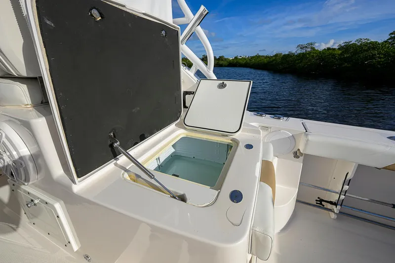  Yacht Photos Pics 2016 Edgewater 335 Express boat with open storage compartment, near waterway.