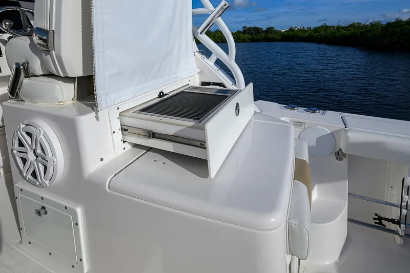  Yacht Photos Pics 2016 Edgewater 335 Express boat with built-in grill and speaker, docked by a serene waterway.