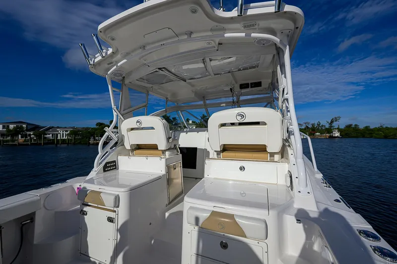  Yacht Photos Pics 2016 Edgewater 335 Express boat interior with seating and storage, under a clear blue sky.